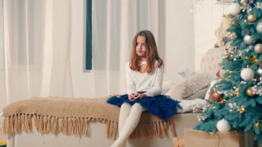 A sad girl receives a gift from her mother for Christmas