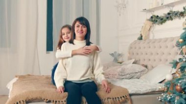 Happy mother with her daughter in the room together on Christmas night