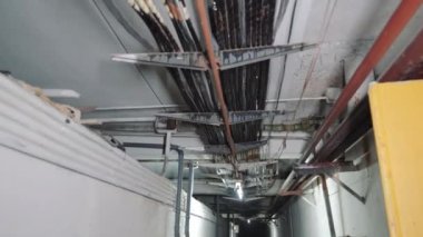Communications of electrical cables and water pipes on the ceiling of the basement. Industrial communications in the technical room are laid under the ceiling