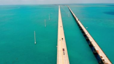 Old Seven Mile Bridge. Drone view of a low-water bridge across the ocean with moving cars. Active movement of vehicles in both directions. A truck on a bridge in the middle of the ocean