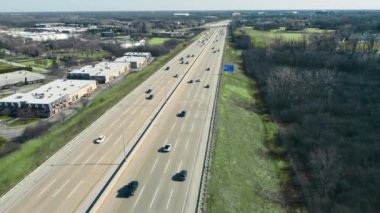 Aerial Flight over the interstate highway. Rush hour and car traffic on the freeway. A large highway with 5 lanes of traffic in one direction. US highways