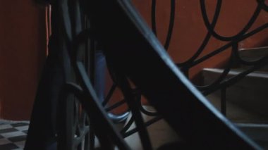 Mens 'in ayağı karanlık bir koridorda merdivenlerden yukarı çıkıyor. Merdivenlerden çıkan çuvallı bir işadamının bacakları.