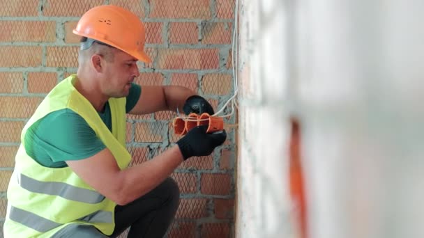 Trabalhador Instala Uma Tomada Reparação Quarto Construção — Vídeo de Stock