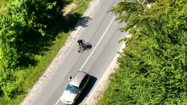 空中からの眺め自転車マラソンに参加し フィニッシュラインに最初に移動する選手サイクリスト 運転者は車からサイクリストを撮影しています — ストック動画