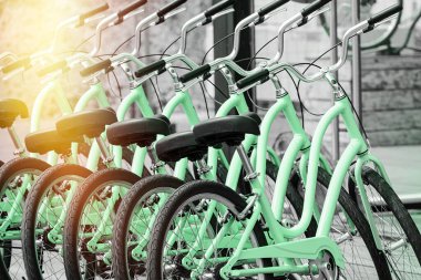 Bisikletler arka arkaya park ediyor ve kiraya vermeye hazır.