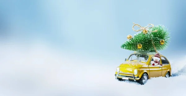 Retro-Spielzeugauto wird von einem Schneemann angetrieben, der den Weihnachtsbaum auf dem Dach trägt . — Stockfoto