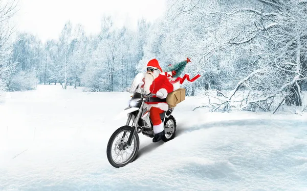 Papai Noel montando uma moto entregando presentes de Natal ou Ano Novo, parcelas na paisagem de inverno de neve. — Fotografia de Stock