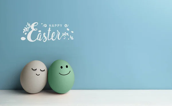 Par de ovos de Páscoa com rostos amorosos com letras felizes da Páscoa — Fotografia de Stock