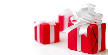 Beyaz arka planda beyaz fiyonklu kırmızı hediye kutuları.