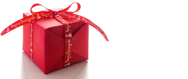 Christmas gift wrapped in red wrapping paper Side view. Copy space. — Stock Photo, Image