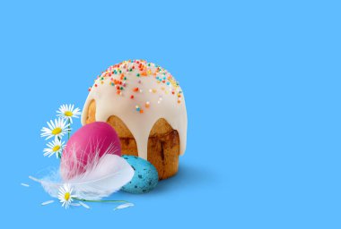 Paskalya pastası ve mavi arka planda çiçekli Paskalya yumurtaları.