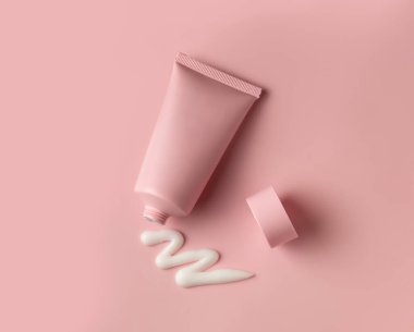 Mockup facial or body cream tube with open cap and white product squeezed cream texture on flesh color background. Top view, copy space clipart