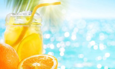 Mavi turkuaz deniz zemininde buz ve portakal meyveli yaz portakal suyu.