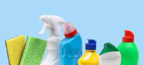 Household cleaning products in plastic bottles on a blue background.
