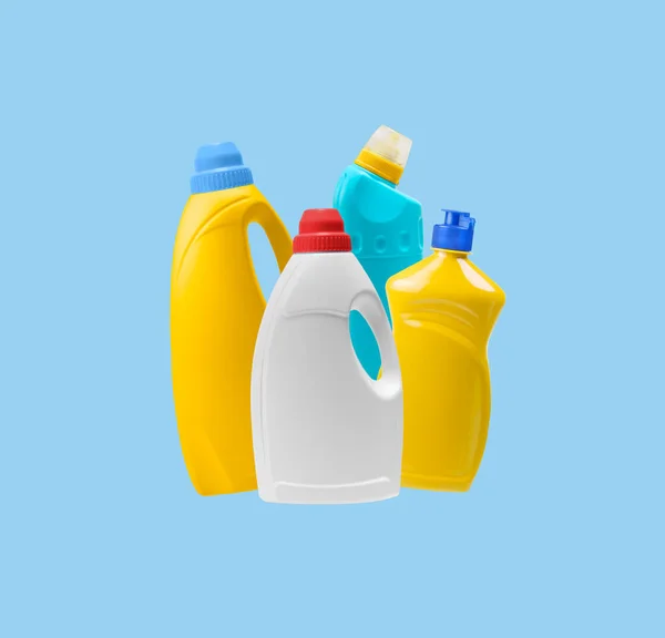 Household cleaning products in plastic bottles isolated on a blue background. Colorful plastic bottles product mockup.