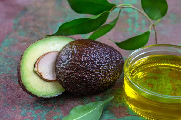 Бутылка авокадо растительное масло с фруктами разрезать пополам — стоковое фото