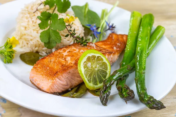 Assiette de saumon, asperges et riz sur planche de bois en attente — Photo