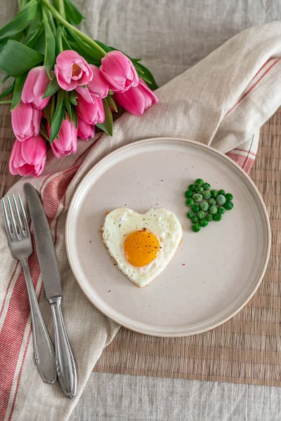 Вкусное Жареное Яйцо Форме Сердца Подаваемое Белой Тарелке Зеленым Горошком — стоковое фото