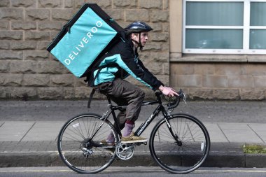 Bristol, İngiltere - 6 Mart 2015: A Deliveroo bike courier ride on a city center street.
