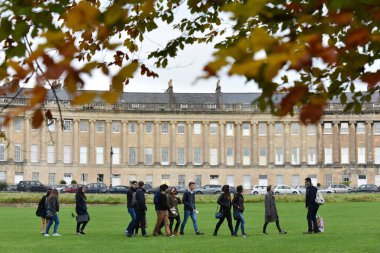 Bath, İngiltere - 28 Eylül 2012: Victoria Park 'ın çimlerine bakan Royal Crescent' i ziyaret eden turistler. Somerset şehri Bath, yılda 4 milyon ziyaretçiyle popüler bir seyahat merkezidir..