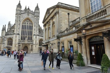 Bath, UK - October 18, 2015:Tourists and locals walk through the courtyard of the historic Bath Abbey and Roman Baths. The Somerset city of Bath receives 4 mln visitors a year.