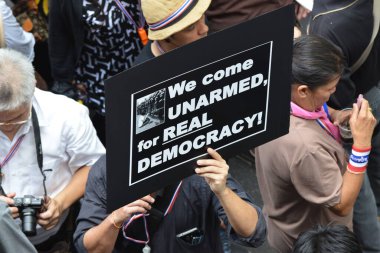 BANGKOK - AUG 7: Protesters confront riot police at a barricade as press photographers jostle for position during an anti government rally near the Thai parliament