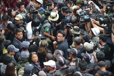 BANGKOK - AUG 7: Protesters confront riot police at a barricade as press photographers jostle for position during an anti government rally near the Thai parliament