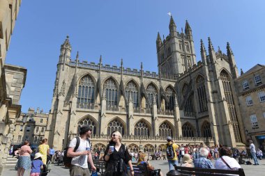 Bath, İngiltere - 23 Temmuz 2014: Bath Abbey 'in avlusunda toplanan turistler ve yerel halk UNESCO' nun dünya mirası statüsüne sahip ve yılda 4 milyon ziyaretçiyle popüler bir seyahat merkezidir..