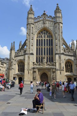 Bath, İngiltere - 23 Temmuz 2014: Turistler ve yerliler Bath Abbey 'in avlusunda toplandılar. Tarihi kent UNESCO dünya mirası statüsüne sahiptir ve yılda 4 milyon ziyaretçiyle popüler bir seyahat merkezidir..