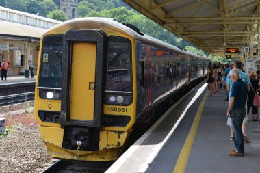 23 Temmuz 2014 - Bath, UK: Tren yolcuları Bath Spa tren istasyonunda beklerken bir tren yaklaşıyor. Somerset şehrinin pitoresk tren istasyonu İngiltere 'nin SW' sine hizmet veren ana istasyondur..
