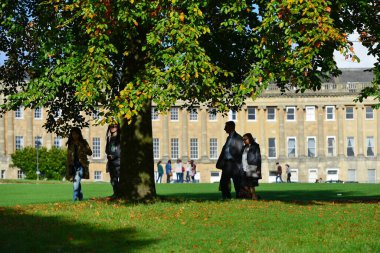Bath, İngiltere - 19 Ekim 2014: İnsanlar Gürcistan Kraliyet Hilal döneminin altında Victoria Parkı 'nda yürüyor. Somerset kenti her yıl 4 milyondan fazla ziyaretçi alıyor..