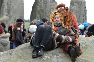 İnsanlar 22 Aralık 2015 'te Stonehenge, İngiltere' de kış gündönümünü kutluyorlar. Yüzlerce şenlikçi, Druid ve putperest antik taş anıtta gündönümünü izledi. .