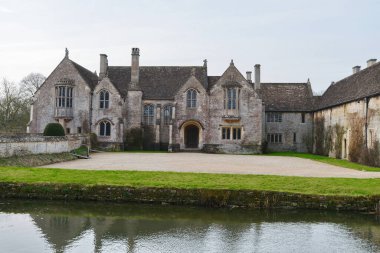 İngiliz köyünde hendeği olan bir malikane manzarası.
