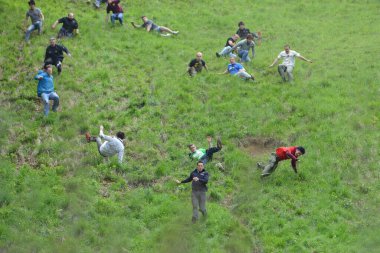 Yarışmacılar, Cooper 's Hill' deki geleneksel peynir yuvarlama yarışlarına 25 Mayıs 2015 'te Brockworth, İngiltere' de katılmaktadır. 19. yüzyıla dayanan onaylanmamış yıllık etkinliğe binlerce kişi katıldı..