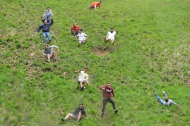 Yarışmacılar, Cooper 's Hill' deki geleneksel peynir yuvarlama yarışlarına 25 Mayıs 2015 'te Brockworth, İngiltere' de katılmaktadır. 19. yüzyıla dayanan onaylanmamış yıllık etkinliğe binlerce kişi katıldı..