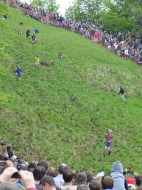 Yarışmacılar, Cooper 's Hill' deki geleneksel peynir yuvarlama yarışlarına 25 Mayıs 2015 'te Brockworth, İngiltere' de katılmaktadır. 19. yüzyıla dayanan onaylanmamış yıllık etkinliğe binlerce kişi katıldı..
