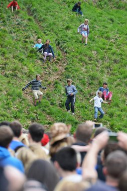 Yarışmacılar, Cooper 's Hill' deki geleneksel peynir yuvarlama yarışlarına 25 Mayıs 2015 'te Brockworth, İngiltere' de katılmaktadır. 19. yüzyıla dayanan onaylanmamış yıllık etkinliğe binlerce kişi katıldı..