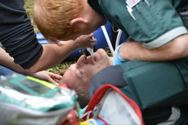 25 Mayıs 2015 'te Brockworth, İngiltere' de Cooper 's Hill' de yapılan geleneksel peynir yuvarlama yarışları sırasında yaralı bir yarışçı sağlık görevlilerinden tedavi görüyor. Onaylanmamış yıllık etkinliğe binlerce kişi katıldı.