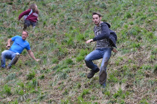 Yarışmacılar, Cooper 's Hill' deki geleneksel peynir yuvarlama yarışlarına 25 Mayıs 2015 'te Brockworth, İngiltere' de katılmaktadır. 19. yüzyıla dayanan onaylanmamış yıllık etkinliğe binlerce kişi katıldı..