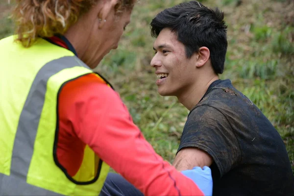 25 Mayıs 2015 'te Brockworth, İngiltere' de Cooper 's Hill' de yapılan geleneksel peynir yuvarlama yarışları sırasında yaralı bir yarışçı sağlık görevlilerinden tedavi görüyor. Onaylanmamış yıllık etkinliğe binlerce kişi katıldı.