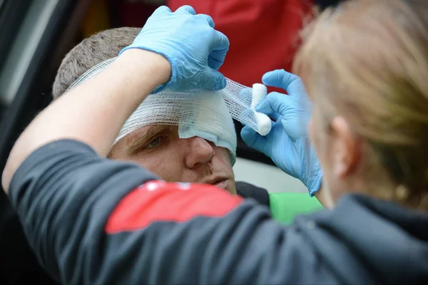 25 Mayıs 2015 'te Brockworth, İngiltere' de Cooper 's Hill' de yapılan geleneksel peynir yuvarlama yarışları sırasında yaralı bir yarışçı sağlık görevlilerinden tedavi görüyor. Onaylanmamış yıllık etkinliğe binlerce kişi katıldı.