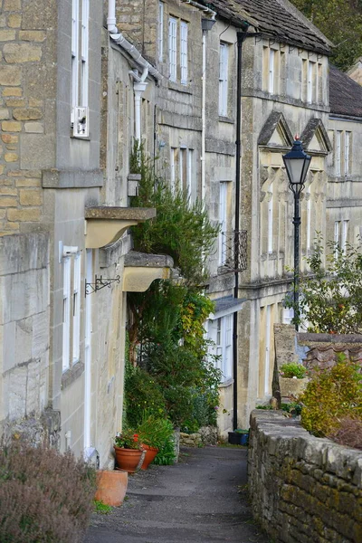 英国小镇上的一座漂亮的老房子和花园的外景 它有美丽的花朵 盆栽和绿叶繁茂的树木 — 图库照片