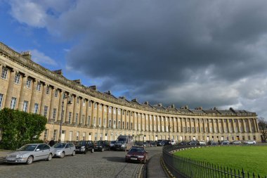 28 Nisan 2015 tarihinde Bath, İngiltere 'de Royal Crescent' de park edilmiş araçlar bulunmaktadır. UNESCO Dünya Mirası kenti yılda 4 milyon ziyaretçi toplarken, turizm yerel ekonomide önemli rol oynuyor.