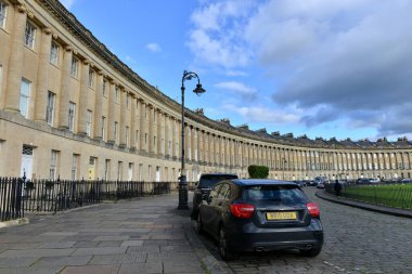 28 Nisan 2015 tarihinde Bath, İngiltere 'de Royal Crescent' de park edilmiş araçlar bulunmaktadır. UNESCO Dünya Mirası kenti yılda 4 milyon ziyaretçi toplarken, turizm yerel ekonomide önemli rol oynuyor.