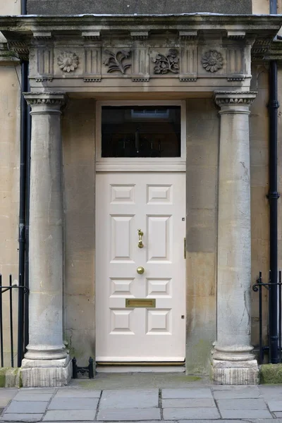 View of a front door and porch of a beautiful old town house on a street in an English city