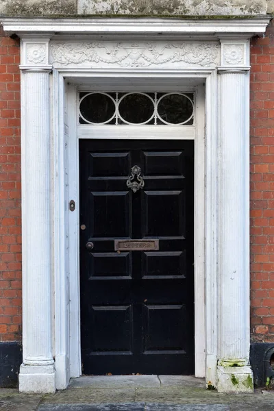 View of a front door and porch of a beautiful old town house on a street in an English city