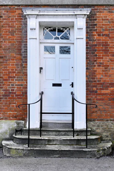 View of a front door and porch of a beautiful old town house on a street in an English city