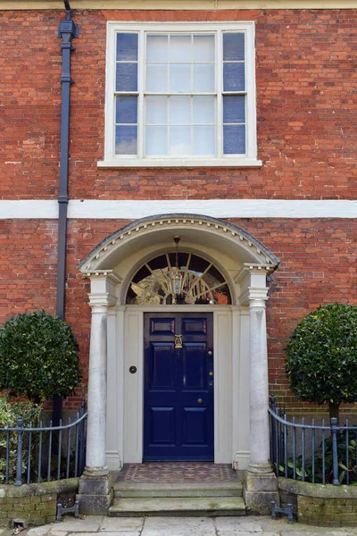 View of a front door and porch of a beautiful old town house on a street in an English city