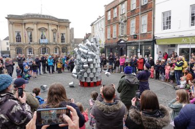 Kalabalık, 1 Mayıs 2022 'de İngiltere' nin Devizes kentinde şehir merkezindeki bir pazar meydanındaki sokak performansını izliyor..