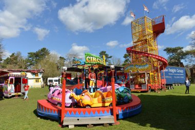 İnsanlar 25 Mart 2016 'da Trowbridge, İngiltere' deki şehir parkındaki gezici bir lunaparka gidiyorlar..